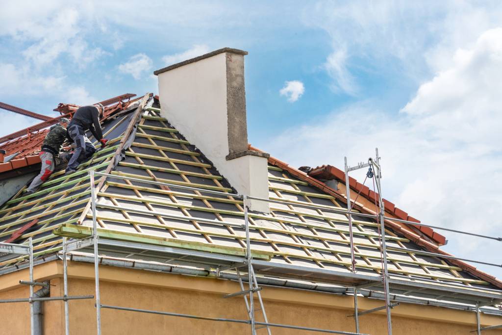 Two Workers Are Working on the Roofing Replacement of a House